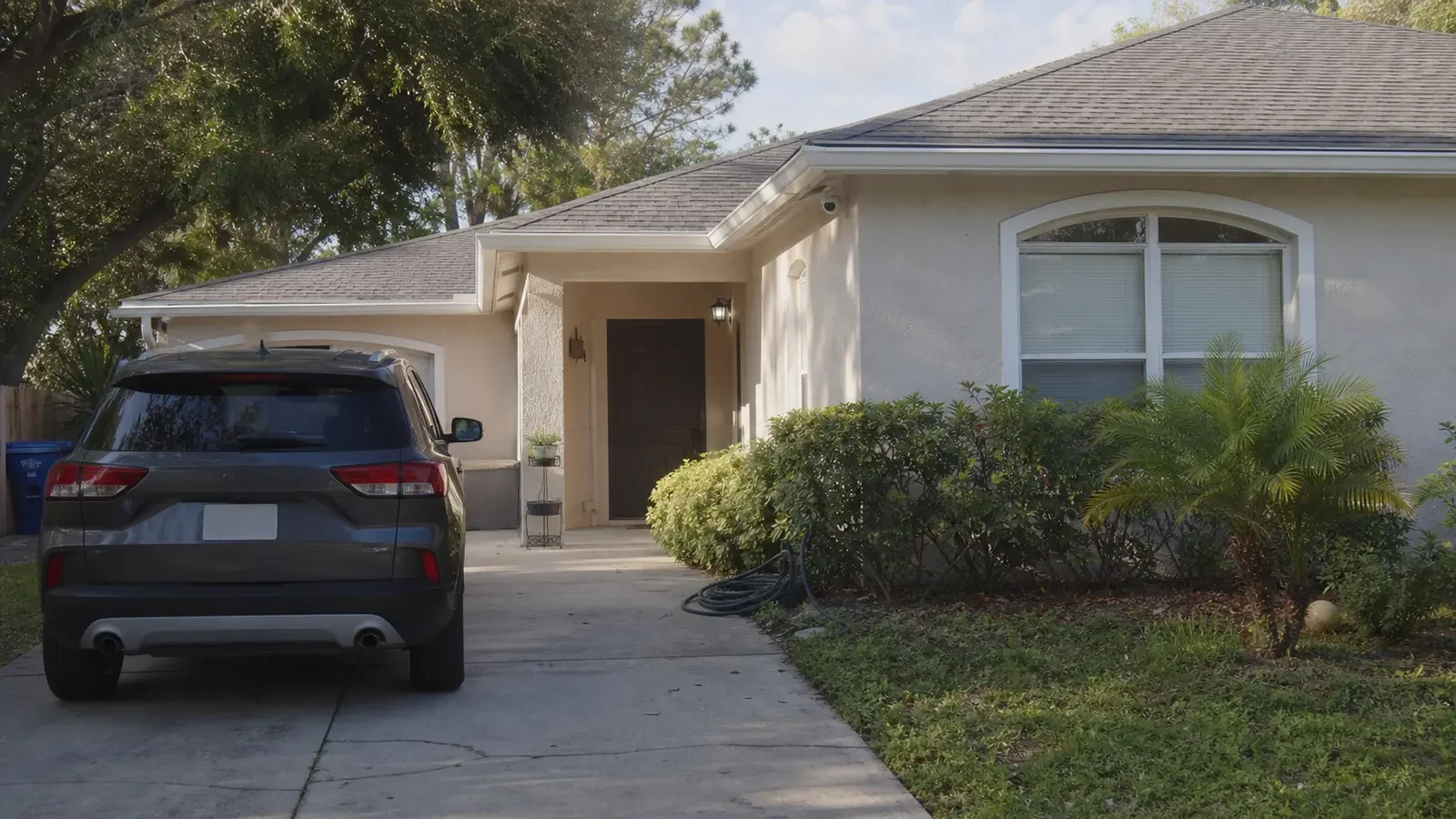 Florida residence with a discreet security camera mounted high above the driveway entrance.
