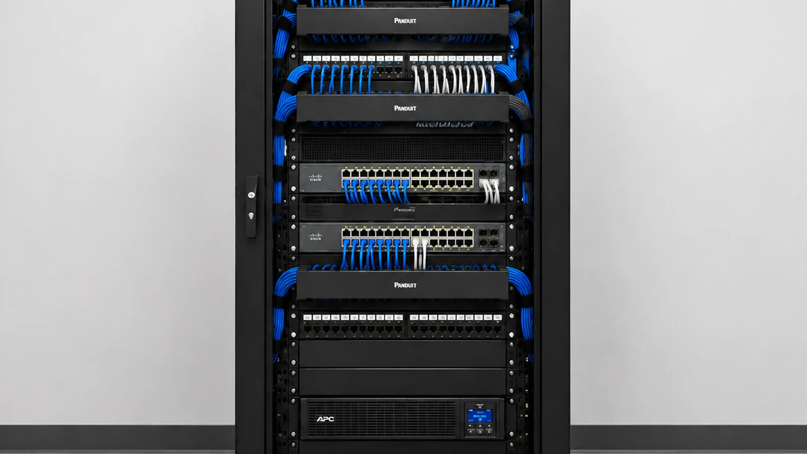 Floor-standing network rack with neatly organized blue patch cords and active network equipment.