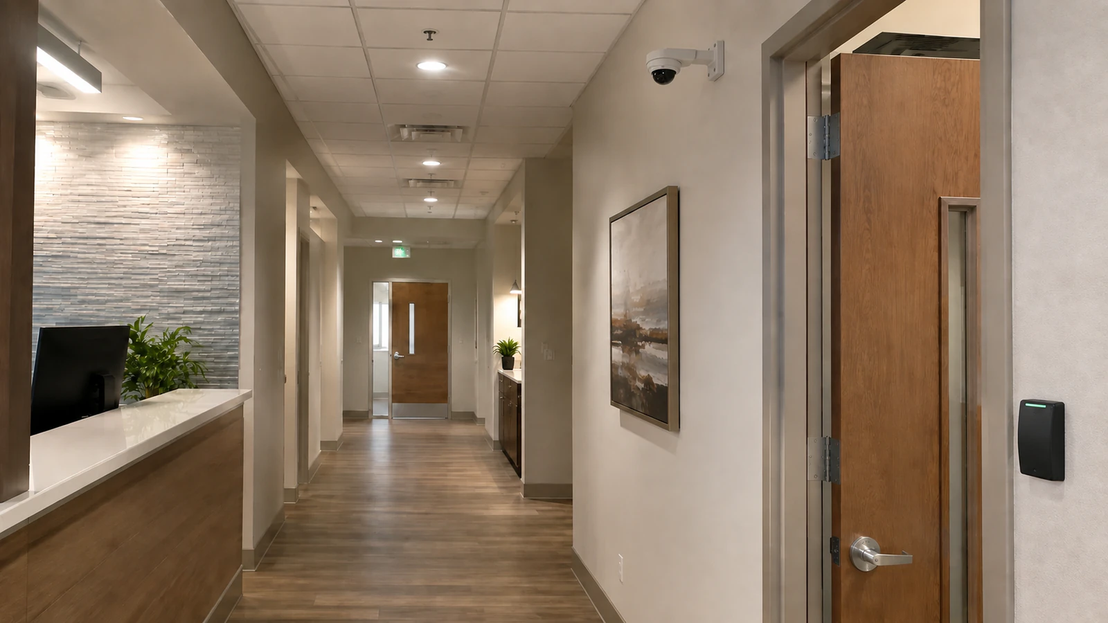 Healthcare reception corridor with a dome camera secured to a wall bracket and a staff-door access reader