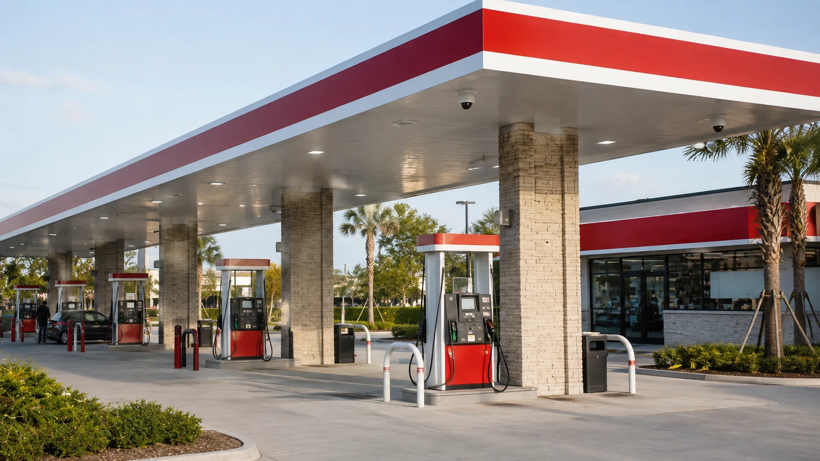 Modern urban gas station with a red-and-white canopy and multiple fuel pumps